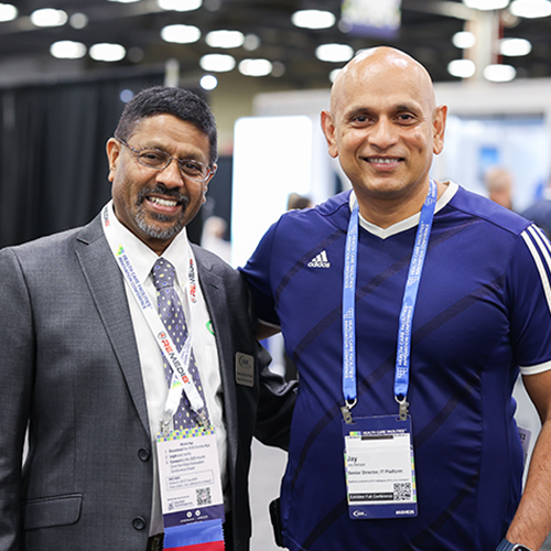 two men smiling looking at camera smiling standing in exhibit hall