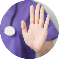 health care worker wearing scrubs holding hand up to sign stop